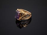 a gold ring with an amethorate stone in the center