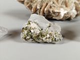 two pieces of crystal on a table next to a shell
