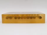 a gold plate with four circles on it on a white surface