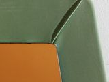 a green chair with a brown seat and a mirror on the wall