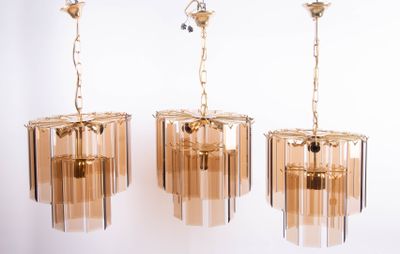 trois lustres en verre suspendus au plafond d'une pièce