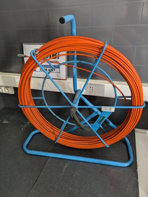 an orange and blue hose sitting on a blue stand