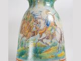 a vase with a painting on it that is sitting on a table