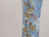 a blue vase that has a bear and a bird on it