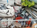 a pile of pipes and pipes in a pile next to a fence