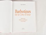 the book is open on a white surface with a red border