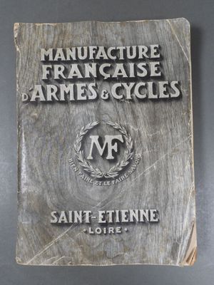 un vieux livre sur lequel est inscrit « Manufacture Française d'Armes et de Cycles »