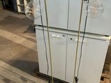 two lamps that are on the floor next to a refrigerator