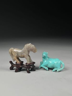 two figurines of horses and a dog on a table