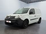 La camionnette blanche est garée dans une grande pièce au sol noir.