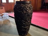 un vase noir posé sur une table dans une pièce