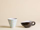 deux tasses à café posées l'une à côté de l'autre sur une table