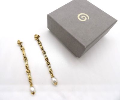 deux paires de boucles d'oreilles dans un écrin posé sur une surface blanche