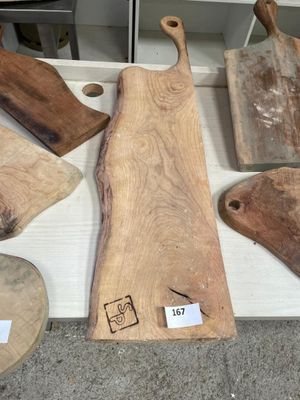 several wooden cutting boards on a table with tags on them