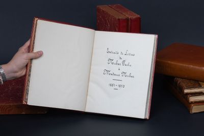 une personne tenant un livre ouvert sur lequel figurent des inscriptions