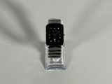 a watch sitting on a clear stand on a white surface