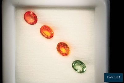 trois pierres précieuses de couleurs différentes dans une boîte blanche