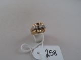 une bague en or ornée d'une fleur et à laquelle est attachée une étiquette de prix