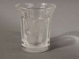 a small glass cup with ice in it sitting on a table