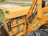 a tractor that is sitting in the grass by the road