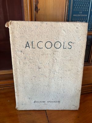 an old book sitting on top of a wooden table next to a book shelf