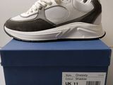 une paire de baskets blanches et noires posée sur une boîte bleue