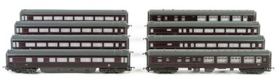 two trains that are sitting side by side on a white surface