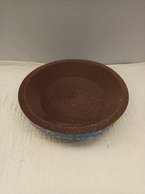un bol marron et bleu posé sur une nappe blanche, sur fond blanc