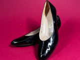 pair of black shoes on a pink background