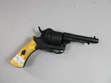 un pistolet jouet posé sur une table, avec une étiquette dessus
