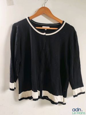 une photo d'un pull noir et blanc suspendu à un cintre