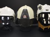 three helmets are lined up in a row on a black surface