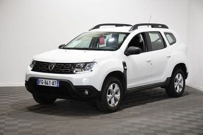 la dacia blanche est garée dans une pièce au sol en damier