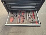 une boîte à outils posée par terre, contenant des outils