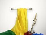 une écharpe jaune, rouge, verte et bleue suspendue à un portant à vêtements