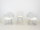 three white chairs in a room with a white wall and a white floor