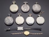 many different types of pocket watches on the table