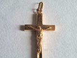 a gold cross with jesus on it on a white surface