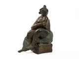 statue d'une femme assise sur un rocher avec un chien