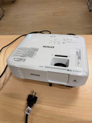 a white projector sitting on top of a wooden table