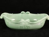 a green bowl with a handle on a black background