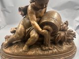figurine en bronze représentant un garçon avec un tonneau de vin