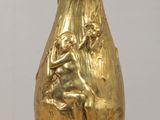 a gold vase sitting on top of a wooden table