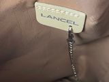 an image of a tan purse with a tag on it