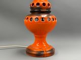 an orange lamp that has holes on it