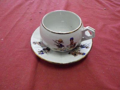 a cup and saucer on a red table cloth