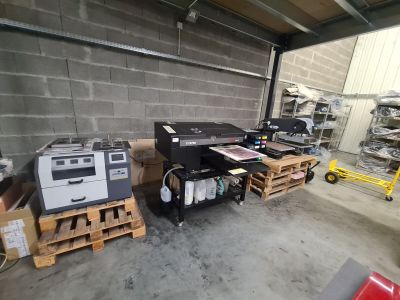 many printers and printers in a warehouse with pallets on the floor