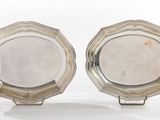 pair of silver plated dishes on stands on a white surface