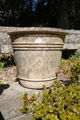 a stone planter sitting on a rock in a garden