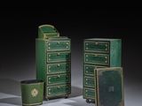 trois meubles peints en vert et or posés sur une surface blanche